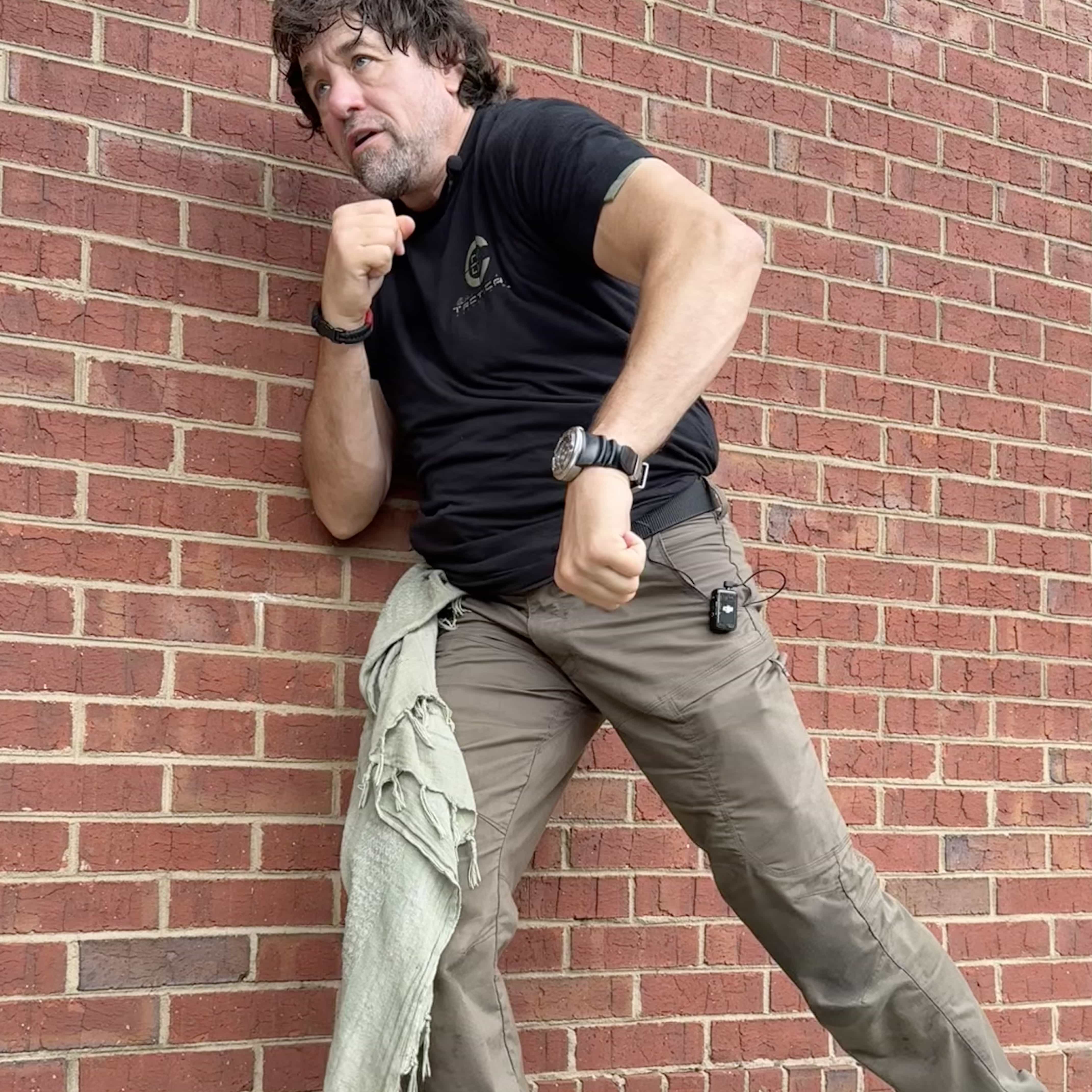 Alan Baker demonstrating protective movement against a brick wall
